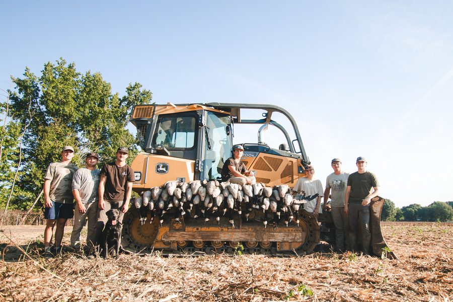 The crew behind a dozer blade lined with geese
