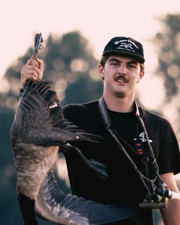 Black Flight Tee with a goose in hand at last light